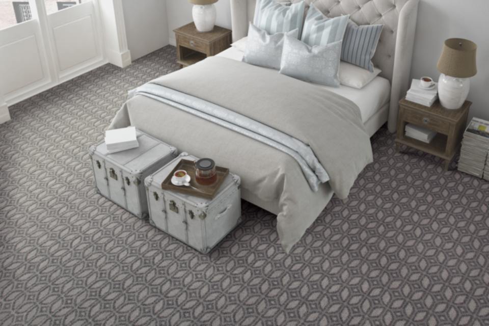 Grey mosaic patterned carpet in bedroom.